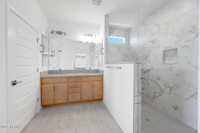 full bath with double vanity, visible vents, a marble finish shower, and a sink