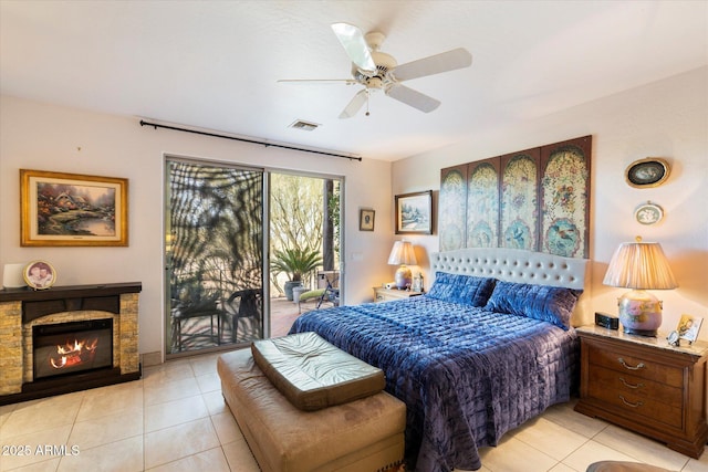 bedroom featuring ceiling fan, a fireplace, light tile patterned floors, and access to outside