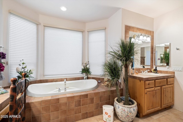 bathroom featuring tile patterned floors, vanity, and tiled bath