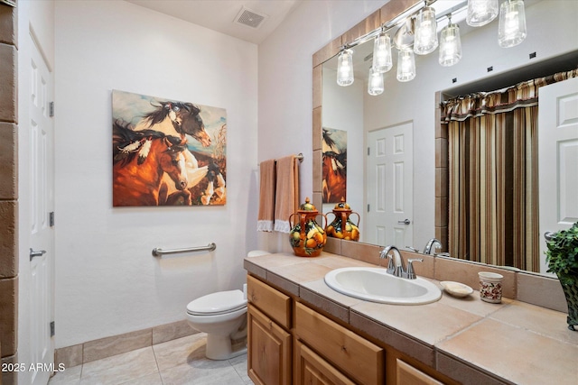 bathroom featuring vanity, toilet, and tile patterned flooring