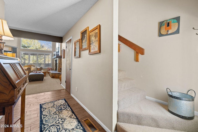 hall with hardwood / wood-style floors and a textured ceiling