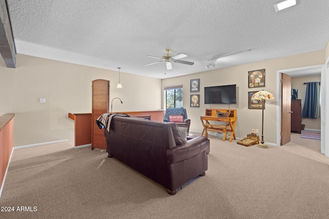 living room with ceiling fan, light colored carpet, track lighting, and a textured ceiling