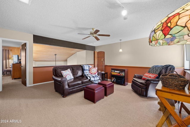 living room with ceiling fan, carpet flooring, lofted ceiling with beams, and a textured ceiling