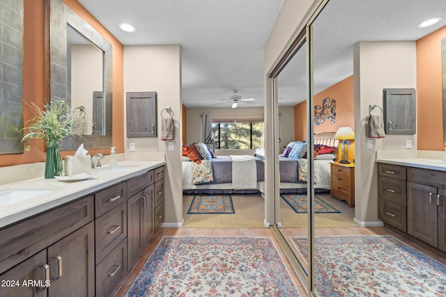 bathroom with vanity, ceiling fan, and a textured ceiling