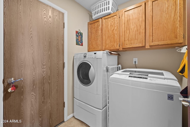 clothes washing area featuring cabinets and washer and clothes dryer