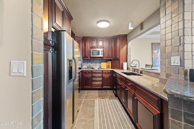 kitchen with sink, light tile patterned floors, stainless steel appliances, light stone countertops, and backsplash