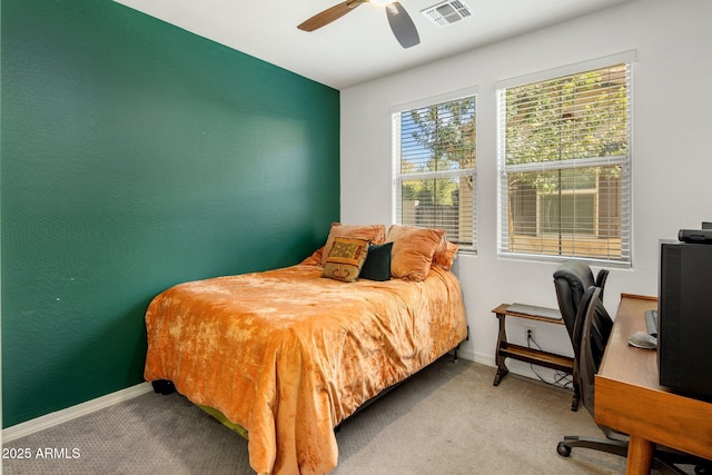 carpeted bedroom featuring visible vents, ceiling fan, baseboards, and a textured wall