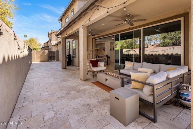 view of patio with an outdoor living space with a fire pit, a fenced backyard, and a ceiling fan