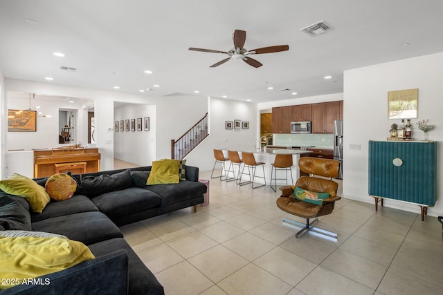 living room featuring stairway, light tile patterned flooring, recessed lighting, and visible vents