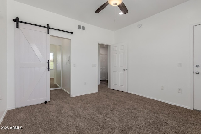 20100 N 78th Pl Unit 2114, Scottsdale, AZ 85255 - unfurnished bedroom with carpet flooring, a barn door, and a ceiling fan