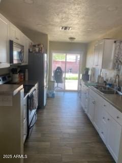 3431 W Campbell Ave, Phoenix, AZ 85017 - kitchen with electric range oven, stainless steel microwave, dark wood-style floors, and white cabinetry