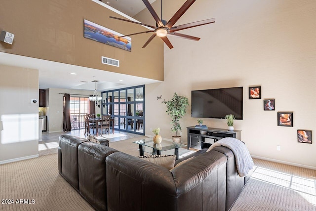 living room with a towering ceiling, light colored carpet, and ceiling fan