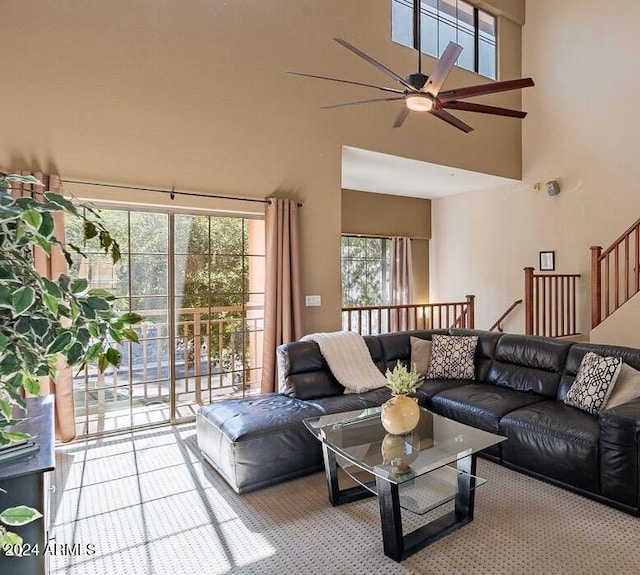 carpeted living room featuring a high ceiling, a wealth of natural light, and ceiling fan