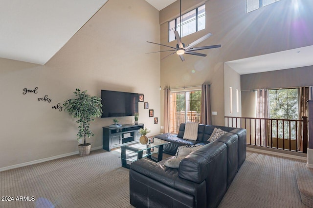 carpeted living room with plenty of natural light, ceiling fan, and a high ceiling