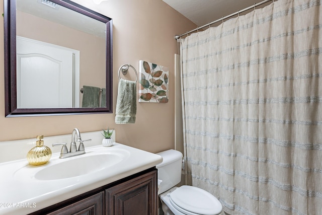 bathroom with a shower with curtain, vanity, and toilet