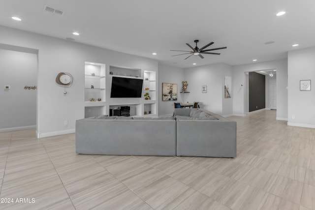 tiled living room featuring built in shelves and ceiling fan