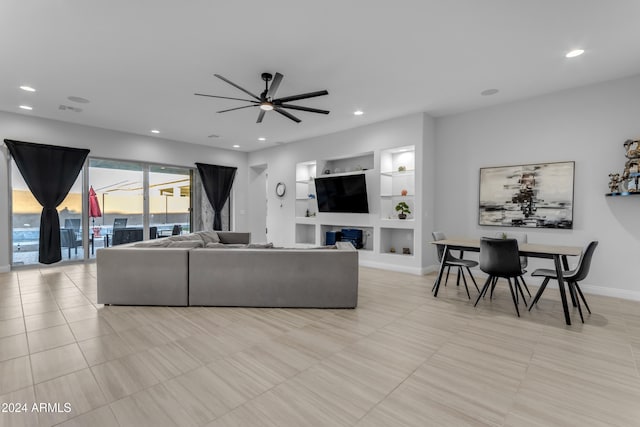 tiled living room featuring built in shelves and ceiling fan