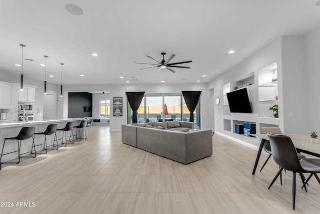 living room featuring ceiling fan and built in features