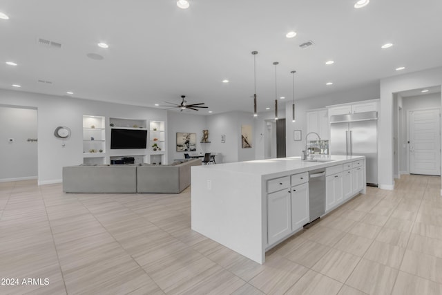 kitchen featuring pendant lighting, a center island with sink, ceiling fan, white cabinetry, and stainless steel built in refrigerator