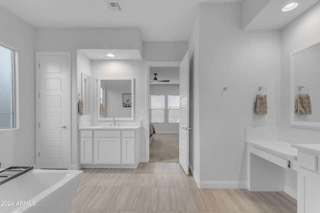 bathroom featuring ceiling fan, vanity, and a bath