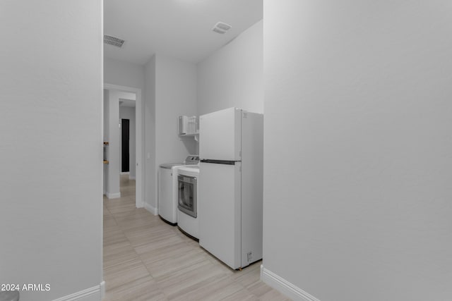 clothes washing area with washing machine and clothes dryer