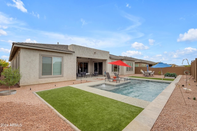 back of property featuring a fenced in pool and a patio