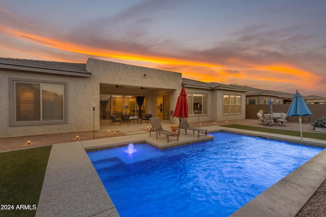 pool at dusk with a patio