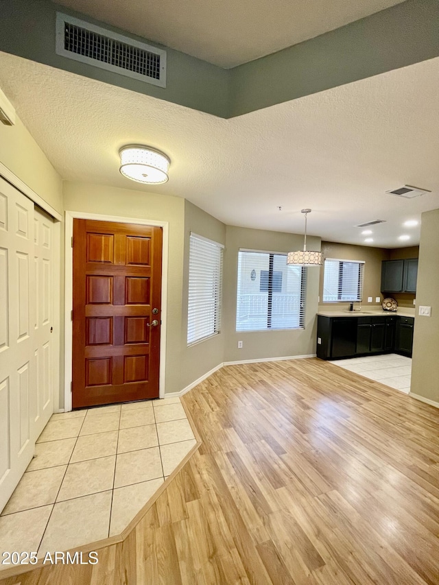 19400 N Westbrook Pkwy Unit 216, Peoria, AZ 85382 - foyer entrance with light wood finished floors, a textured ceiling, visible vents, and a chandelier
