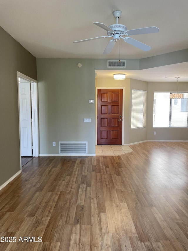 19400 N Westbrook Pkwy Unit 216, Peoria, AZ 85382 - unfurnished living room with ceiling fan, baseboards, visible vents, and wood finished floors