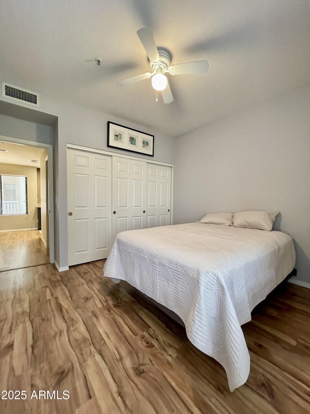 19400 N Westbrook Pkwy Unit 216, Peoria, AZ 85382 - bedroom featuring a closet, visible vents, wood finished floors, and baseboards