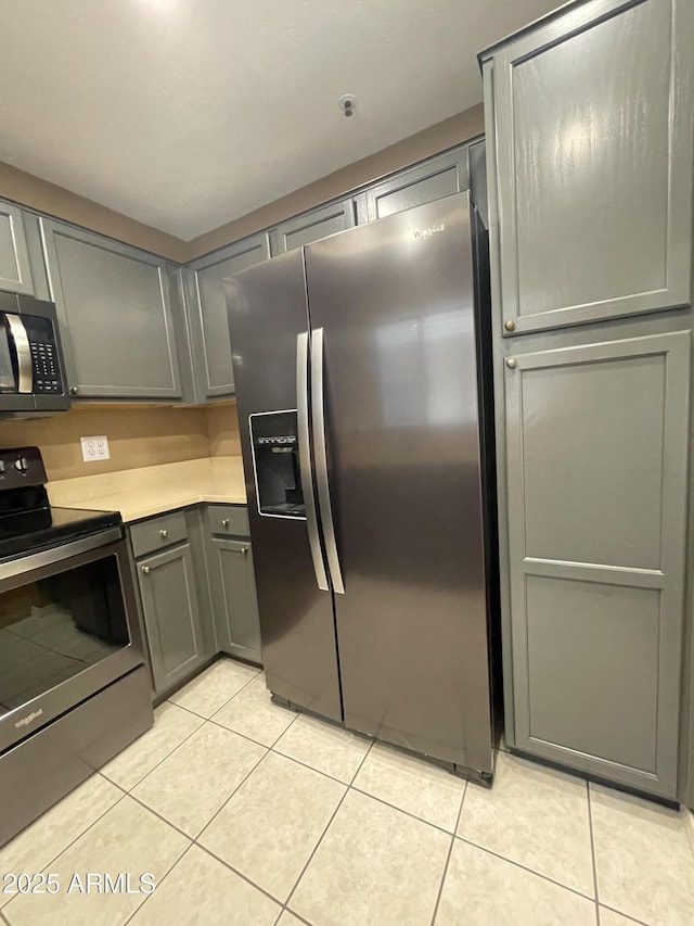 19400 N Westbrook Pkwy Unit 216, Peoria, AZ 85382 - kitchen featuring gray cabinetry, light tile patterned floors, stainless steel appliances, and light countertops