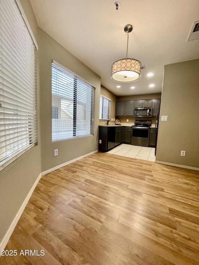 19400 N Westbrook Pkwy Unit 216, Peoria, AZ 85382 - kitchen featuring stainless steel appliances, light countertops, baseboards, and light wood-style floors