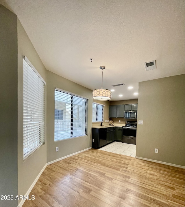 19400 N Westbrook Pkwy Unit 216, Peoria, AZ 85382 - kitchen featuring light wood finished floors, electric range, visible vents, stainless steel microwave, and light countertops