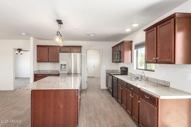31515 W Buchanan St, Buckeye, AZ 85326 - kitchen featuring stainless steel appliances, a center island, hanging light fixtures, and light wood-style floors