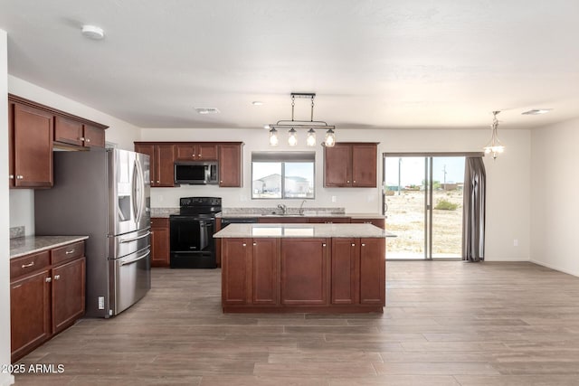31515 W Buchanan St, Buckeye, AZ 85326 - kitchen with stainless steel appliances, wood finished floors, a kitchen island, and decorative light fixtures