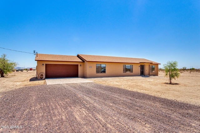 31515 W Buchanan St, Buckeye, AZ 85326 - ranch-style house with dirt driveway, a garage, and stucco siding