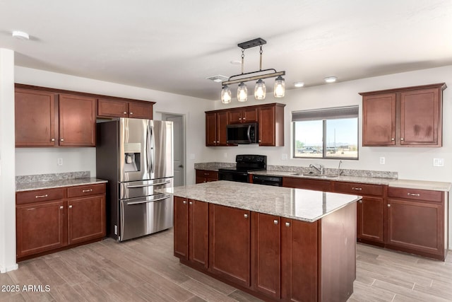 31515 W Buchanan St, Buckeye, AZ 85326 - kitchen featuring black appliances, light wood-type flooring, a kitchen island, and light stone countertops