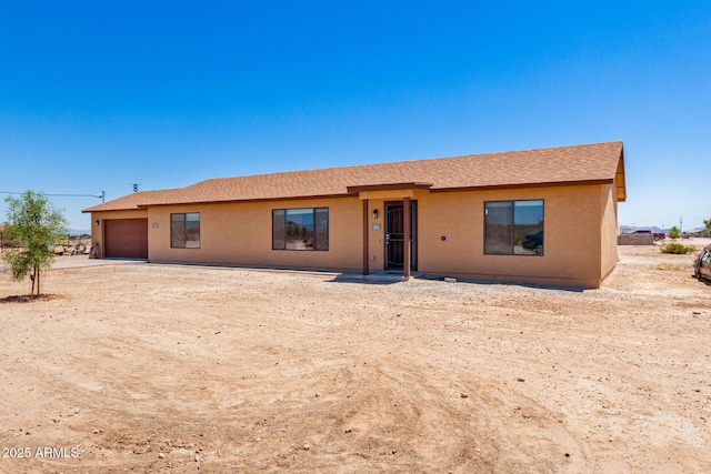 31515 W Buchanan St, Buckeye, AZ 85326 - view of front of home featuring an attached garage, stucco siding, and a shingled roof