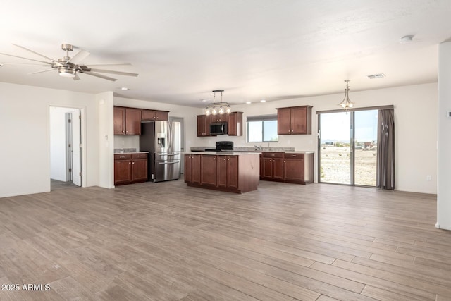 31515 W Buchanan St, Buckeye, AZ 85326 - kitchen featuring appliances with stainless steel finishes, open floor plan, wood finished floors, a ceiling fan, and light countertops