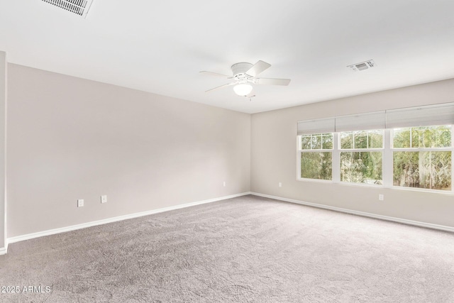 spare room featuring baseboards, visible vents, carpet floors, and ceiling fan