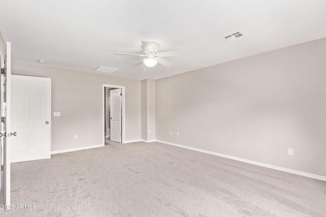 carpeted spare room featuring visible vents, baseboards, and ceiling fan