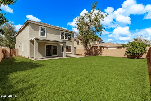 rear view of house with a patio, a yard, a fenced backyard, and stucco siding