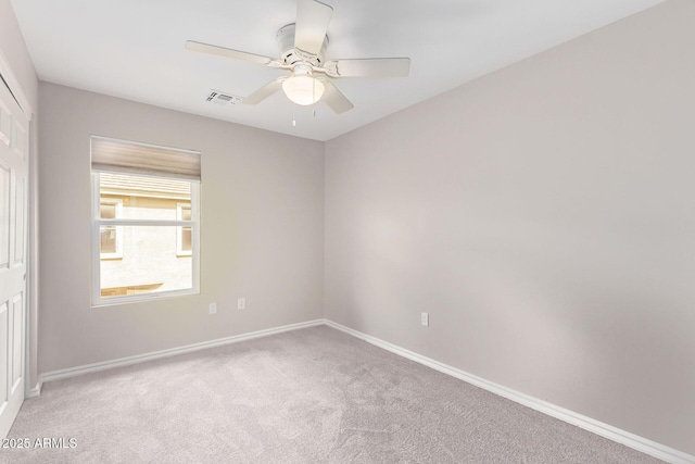 empty room featuring visible vents, baseboards, light colored carpet, and ceiling fan