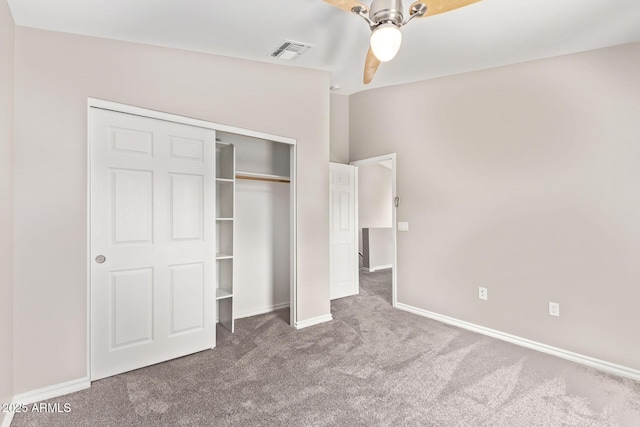 unfurnished bedroom with baseboards, visible vents, lofted ceiling, a closet, and carpet flooring