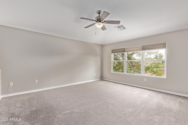 carpeted spare room featuring visible vents, ceiling fan, and baseboards