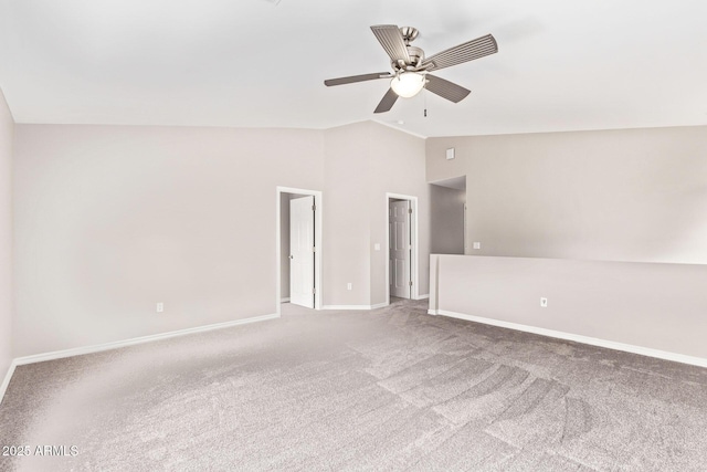 carpeted spare room featuring baseboards, lofted ceiling, and ceiling fan