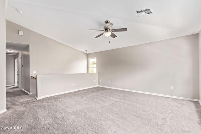 carpeted spare room featuring visible vents, lofted ceiling, baseboards, and ceiling fan