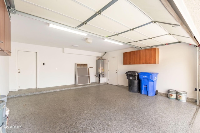 garage with baseboards and water heater