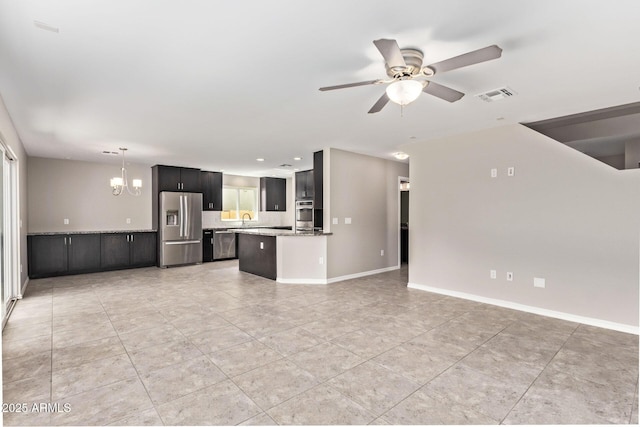 unfurnished living room featuring visible vents, ceiling fan with notable chandelier, a sink, light tile patterned floors, and baseboards