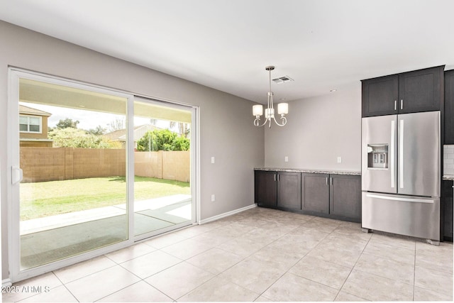 kitchen with visible vents, pendant lighting, stainless steel fridge, light tile patterned floors, and a chandelier